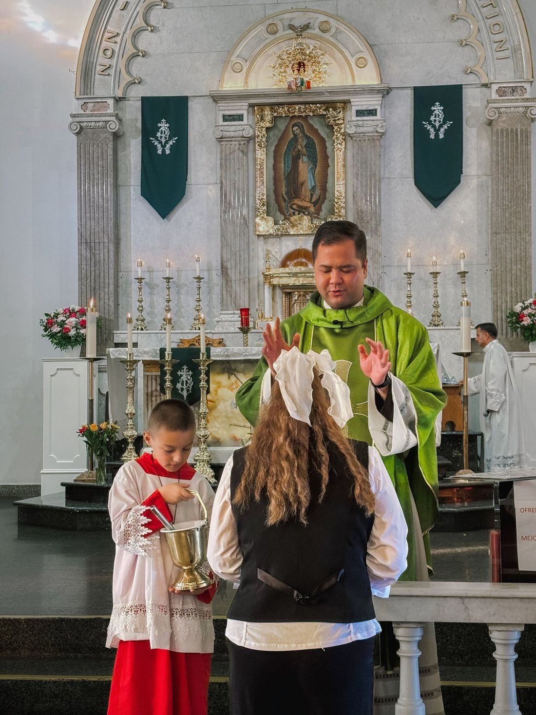 An altar server holding a cruet