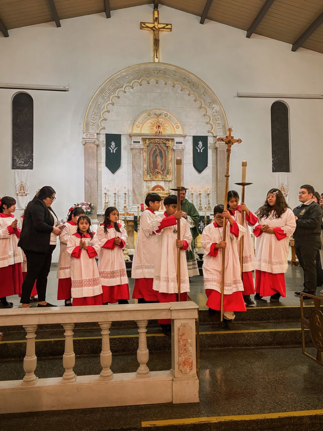 Altar servers in cassocks and surplices gathered with a priest