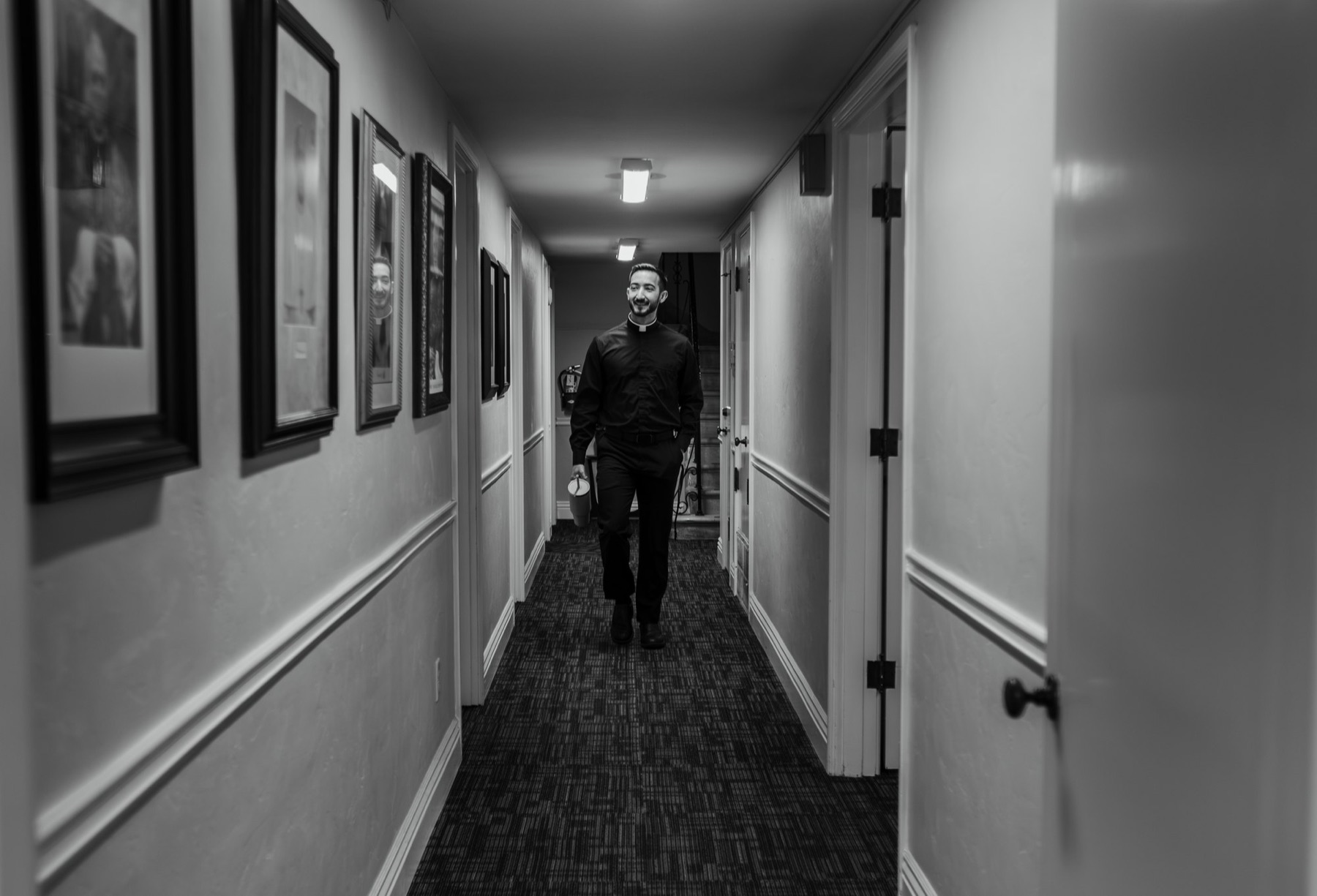 Father Larry Curtis walks down a parish hallway