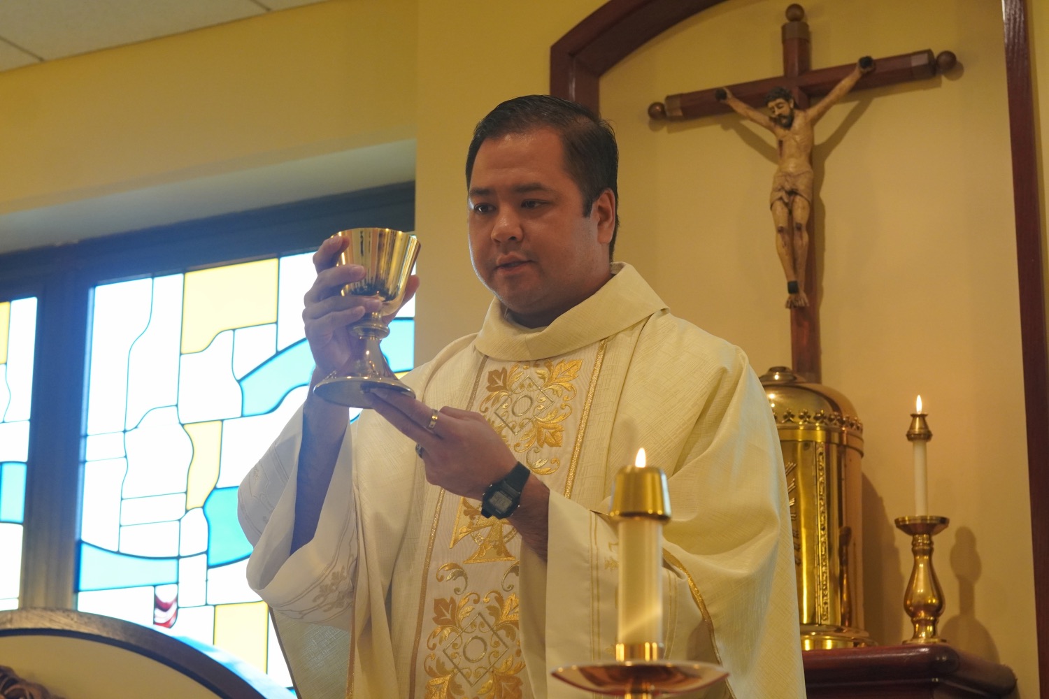 Fr. Hau Vu elevating the chalice at Mass